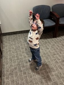 Toddler with Down syndrome gestures up